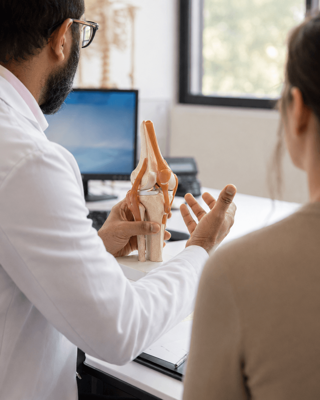 Consultation avec le Dr Moussadjy, chirurgien orthopédiste — explication sur modèle anatomique du genou