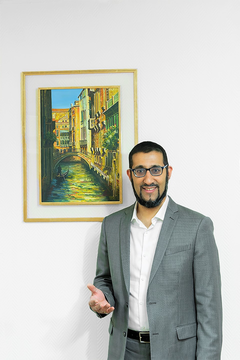 Le Dr Moussadjy souriant devant un tableau représentant Venise dans son cabinet
