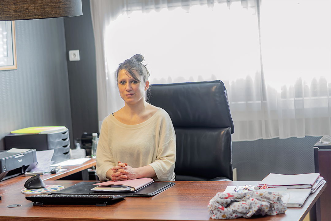 La secrétaire médicale à son bureau d'accueil, souriante et disponible